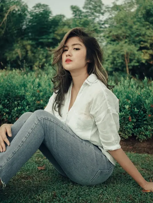 Memadukan kemeja putih dengan celana jeans memang tak ada matinya. Gaya kasual Ochi Rosdiana ini tentunya bisa ditiru untuk hangout. (Liputan6.com/IG/@ochi24)