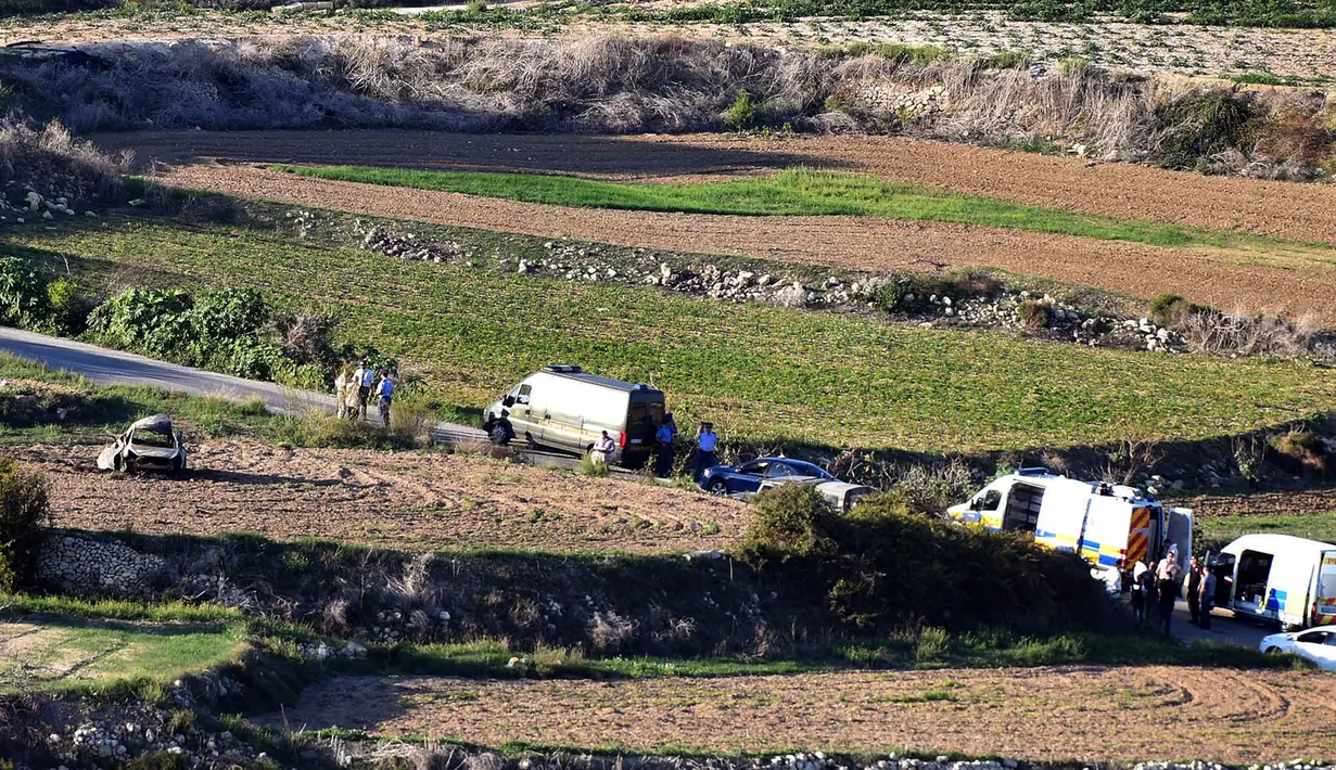 Kendaraan polisi dan ambulans terparkir di sepanjang jalan lokasi meledaknya mobil jurnalis investigasi, Daphne Caruana Galizia, di kota Mosta, Malta, Senin (16/10). Galizia tewas seketika dan mobilnya terlempar ke sebuah lapangan. (AP/Rene Rossignaud)