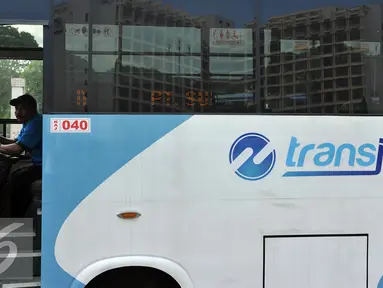 Supir Kopaja terintegrasi Transjakarta terparkir di Parkir Timur Senayan, Jakarta, Selasa (22/12). Saat ini terdapat 320 bus tampilan baru Kopaja AC yang akan beroperasi di rute-rute yang terintegrasi.  (Liputan6.com/Johan Tallo)