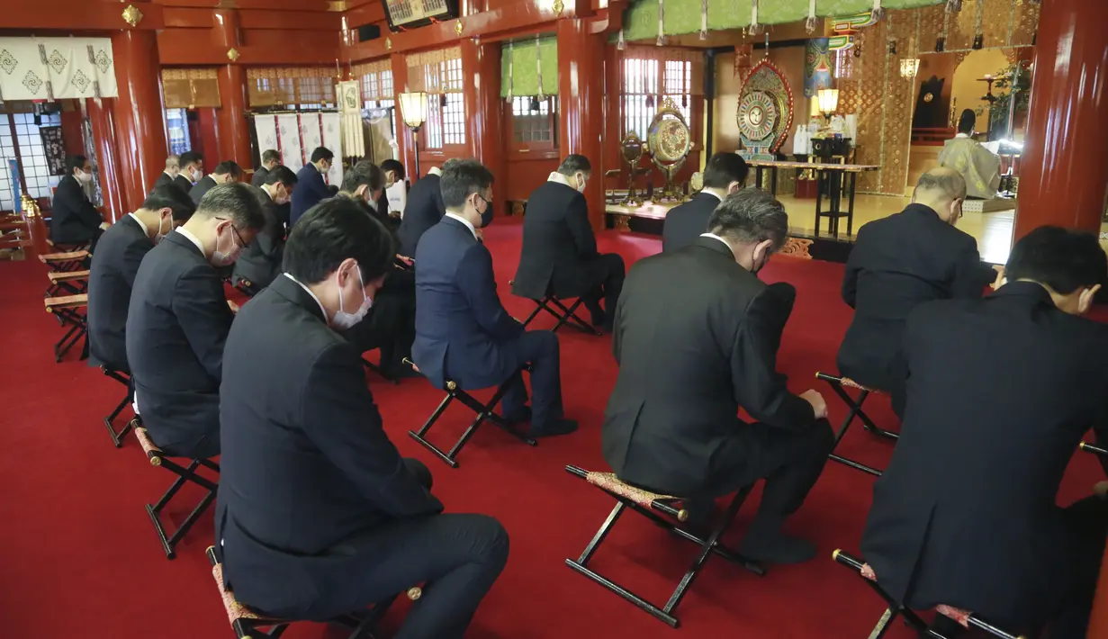 Tradisi berdoa untuk Tahun Baru pada hari kerja pertama tahun ini di Kuil Kanda Myojin, di Tokyo, Jepang, Senin (4/1/2021). Kebanyakan pengunjung mendatangi kuil tersebut untuk mencari keberuntungan dalam bisnis. (AP Photo/Koji Sasahara)