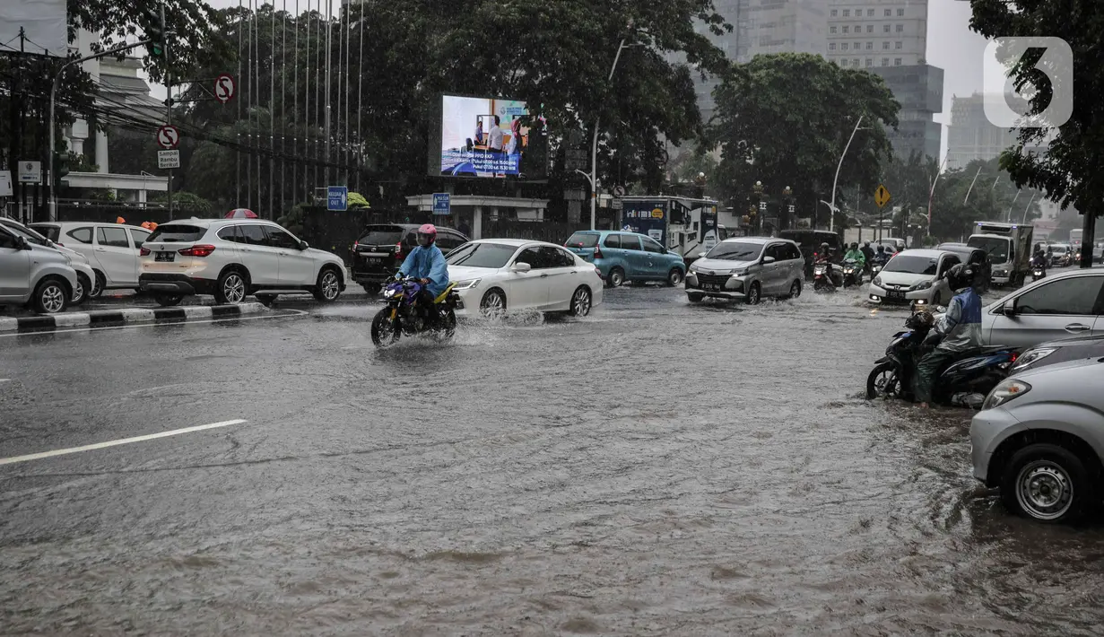 Sejumlah kendaraan melintasi genangan air di Jalan Medan Merdeka Timur, Jakarta, Jumat (24/1/2020). Hujan deras yang mengguyur Jakarta sejak pagi tadi mengakibatkan genangan air di Jalan Medan Merdeka Timur. (Liputan6.com/Faizal Fanani)
