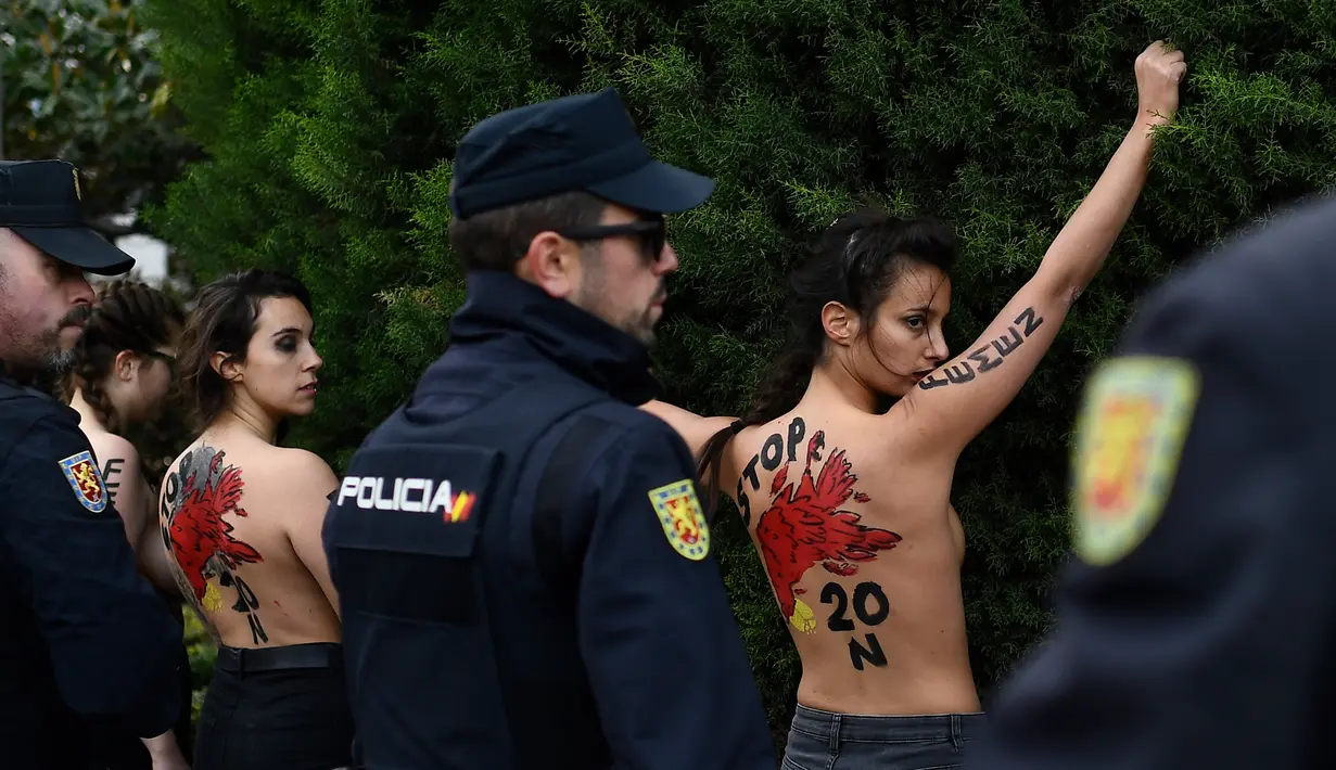 Polisi Spanyol menahan sejumlah aktivis Femen yang melakukan aksi telanjang dada memprotes penggalian makam diktator Spanyol Francisco Franco selama pertemuan tahunan di Madrid, Spanyol (24/11/2019). Aksi ini sekaligus memperingati kematian ke-44 Francisco Franco. (AFP/Oscar Del Pozo)