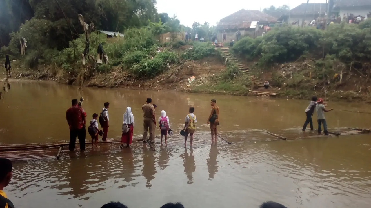 Nampak para siswa dan pejabat Garut yang tengah melakukan inspeksi ke lokasi, tengah menyebrangi sungai Cimanuk menggunakan rakit bambu