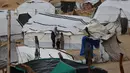 Kepala Kantor Media Pemerintah di Gaza, Ismail Thawabta, mengonfirmasi dari sekitar 135.000 tenda yang tersebar di kamp-kamp pengungsian, 127.000 di antaranya tidak memenuhi standar kelayakan. Tampak dalam foto, seorang pria Palestina yang mengungsi memperbaiki tenda yang didirikan di sepanjang pantai Kota Gaza saat angin musim dingin yang kencang menerpa wilayah tersebut pada Selasa 13 Januari 2026. (Omar AL-QATTAA/AFP)
