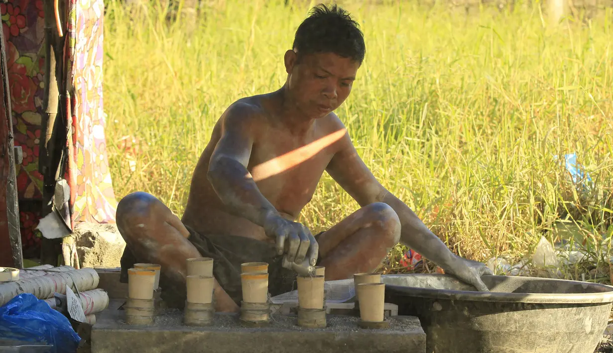 Seorang pekerja menambahkan bubuk mesiu ke dalam silinder karton untuk membuat kembang api di dalam pondok di kota Bocaue, provinsi Bulacan, Filipina, (26/12/2015) Desember 2015. (REUTERS/Romeo Ranoco)