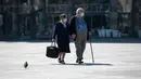 Pasangan lansia mengenakan masker saat berjalan di Alun-Alun Beograd, Serbia, 17 Maret 2020. Organisasi Kesehatan Dunia (WHO) mengumumkan virus corona COVID-19 sebagai pandemi sejak 11 Maret 2020 lalu. (Andrej ISAKOVIC/AFP)