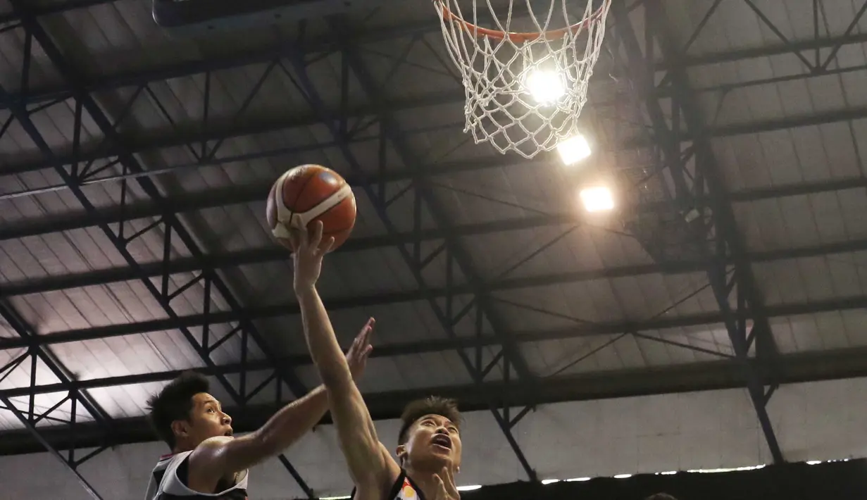 Pemain M88 Aspac Jakarta, Rizky Effendi (kiri) menghalau tembakan pemain NSH Jakarta, Yoseph Wiajay pada laga IBL Reguler Season di Hall A Senayan, Jakarta, Minggu (10/1/2016). Aspac Jakarta menang 78-61. (Bola.com/Nicklas Hanoatubun)