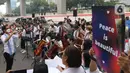 Komposer Addie MS memimpin penampilan orkestra saat aksi seruan damai di depan Kedutaan Besar Federasi Rusia, Jakarta, Rabu (30/3/2022). Aksi tersebut mengangkat tema "Setangkai Kembang dan Satu Nyanyian" dengan membawakan lagu Rayuan Pulau Kelapa versi bahasa Rusia. (Liputan6.com/Herman Zakharia)