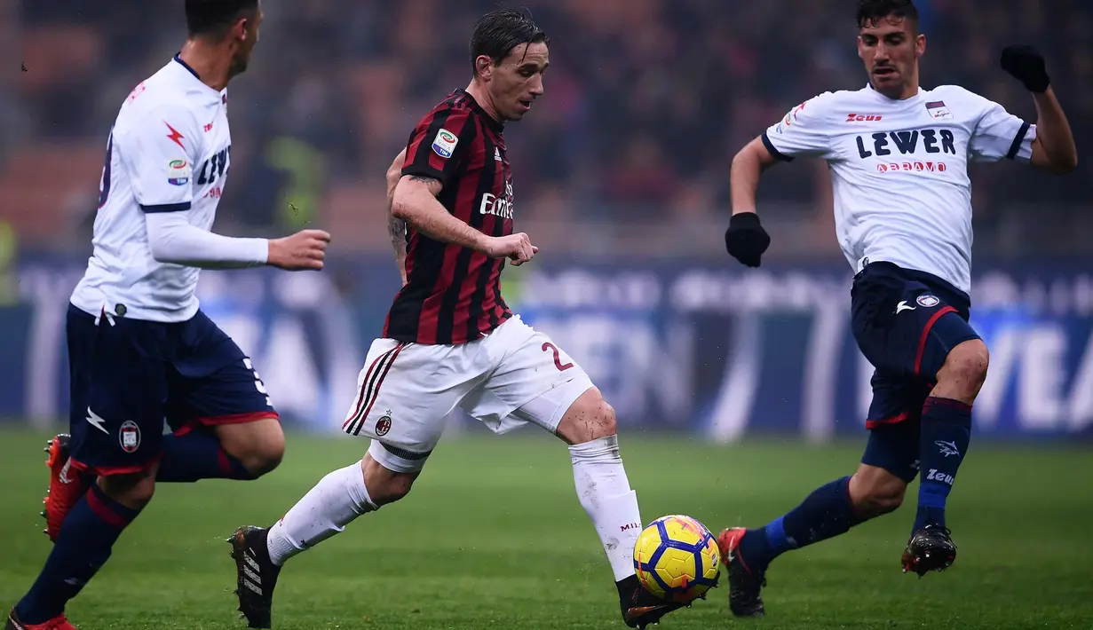 Gelandang AC Milan, Lucas Biglia berusaha membawa bola dari kawalan dua pemain Crotone saat bertanding pada lanjutan Liga Serie A Italia di San Siro, Milan (6/1). Milan menang tipis 1-0 atas Crotone. (AFP Photo/Marco Bertorello)