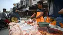 Pedagang memotong daging ayam saat melayani pembeli di sebuah pasar tradisional usai gempa dan tsunami melanda Palu, Sulawesi Tengah, Kamis (4/10). Pedagang mengaku memperdagangkan barangnya dengan harga standar. (Permata SAMAD/AFP)