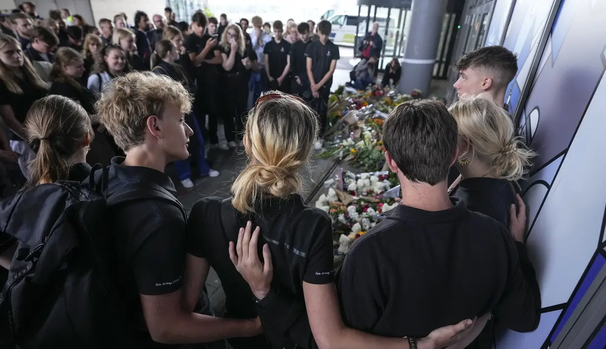Orang-orang berkumpul untuk meletakkan bunga pada pintu masuk pusat perbelanjaan Field di Kopenhagen, Denmark, 5 Juli 2022. Pihak berwenang pada hari Senin mengajukan dakwaan awal pembunuhan dan percobaan pembunuhan terhadap seorang pria Denmark berusia 22 tahun. (AP Photo/Sergei Grits)