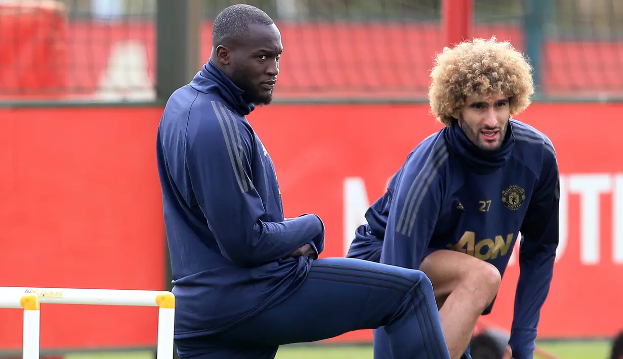 Pemain MU Romelu Lukaku dan Marouane Fellaini  melakukan pemanasan saat latihan di AON Training Complex, Carrington, Inggris (1/10). MU akan bertanding melawan wakil Spanyol, Valencia di Old Trafford. (AFP Photo/Lindsey Parnaby)