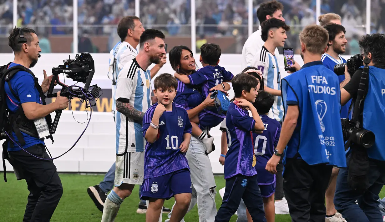 Pemain Argentina, Lionel Messi merayakan kemenangan timnya di Piala Dunia 2022 bersama keluarganya setelah mengalahkan Prancis pada laga final yang berlangsung di Lusail Stadium, Qatar, Minggu (18/12/2022). Albiceleste menang 4-2 atas Prancis di babak penalti. (AFP/Kirill Kudryavtev)