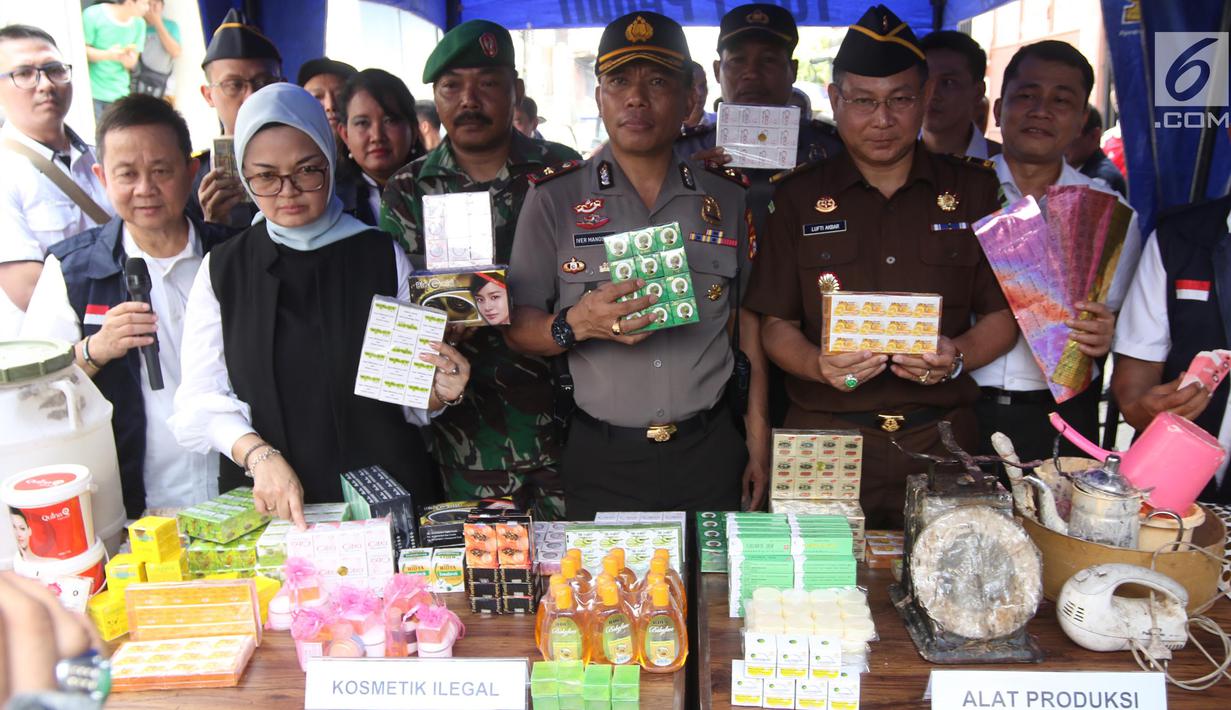 Kepala BPOM RI Penny K Lukito menunjukkan barang bukti kosmetik palsu di kawasan Tambora, Jakarta Barat, Selasa (15/5). Petugas menemukan 21 item produk jadi kosmetik ilegal, bahan baku, dan alat produksi. (Liputan6.com/Arya Manggala)