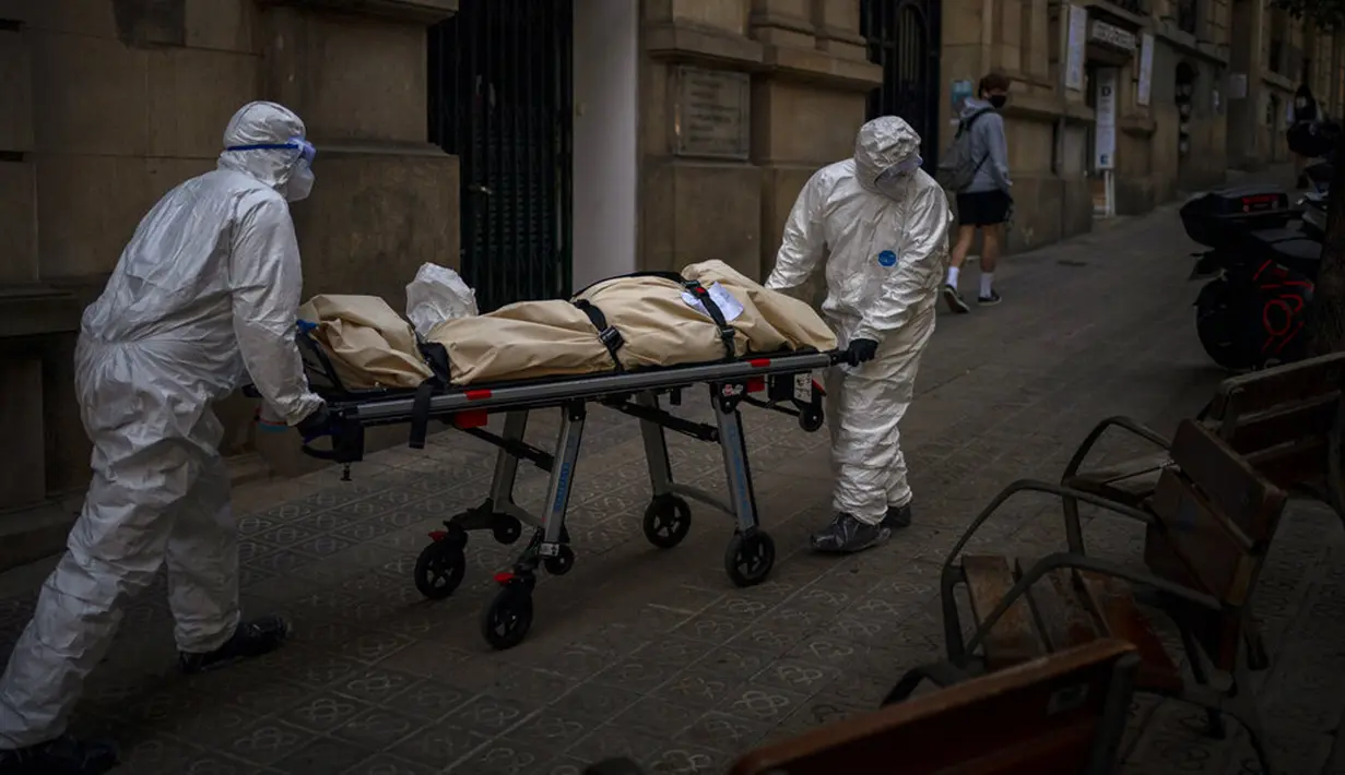 Petugas kamar jenazah membawa jenazah lansia yang meninggal karena COVID-19 setelah dikeluarkan dari panti jompo di Barcelona, Spanyol, 13 November 2020. Seperti dokter dan perawat, petugas kamar jenazah adalah bagian dari sekelompok pekerja penting di tengah pandemi. (AP Photo/Emilio Morenatti)