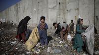 Anak-anak mencari barang-barang plasatik di tempat pembuangan sampah di Kabul, Afghanistan (15/12/2019). Menurut statistik PBB, Afghanistan adalah salah satu negara termiskin di dunia di mana anak-anak menjadi sasaran kemiskinan dan kekerasan ekstrem setiap hari.  (AP Photo/Altaf Qadri)