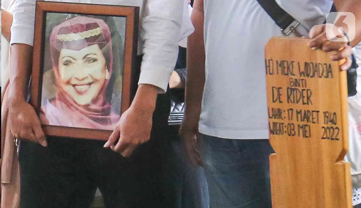 <p>Kerabat membawa foto aktris senior Mieke Wijaya saat prosesi pemakaman di TPU Tanah Kusir, Jakarta, Rabu (4/5/2022). Mieke Wijaya meninggal dunia pada Selasa, 3 Mei 2022 di Jakarta. Ia meninggal dunia pada usia 82 tahun. (Liputan6.com/Herman Zakharia)</p>