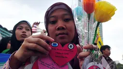 Seorang wanita memperlihatkan tanda cinta yang bertuliskan selamat hari ibu, Jakarta, Minggu (22/12/2014) (Liputan6.com/Johan Tallo)