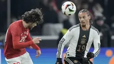 Gelandang Turki Ferdi Kadioglu berebut bola dengan penyerang Jerman Leroy Sane dalam laga uji coba di Olympiastadion, Berlin, Minggu (19/11/2023) dini hari WIB. (AP Photo/Markus Schreiber)
