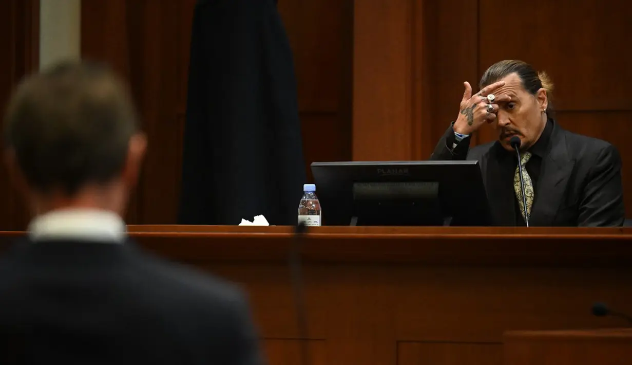 Aktor Johnny Depp bersaksi pada persidangan pencemaran nama baik di Fairfax County Circuit Courthouse, Fairfax, Virginia, Amerika Serikat, 19 April 2022. Johnny Depp menggugat Amber Heard setelah dia menulis artikel opini di The Washington Post pada tahun 2018. (JIM WATSON/POOL/AFP)