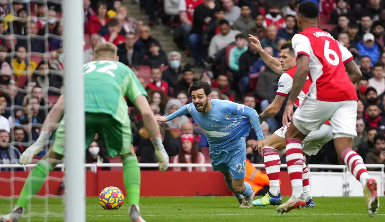 Pemain Arsenal Granit Xhaka (tengah kanan) berebut bola dengan pemain Manchester City Bernardo Silva yang berbuah penalti pada pertandingan sepak bola Liga Inggris di Stadion Emirates, London, Inggris, 1 Januari 2022. Manchester City menang 2-1. (AP Photo/Matt Dunham)
