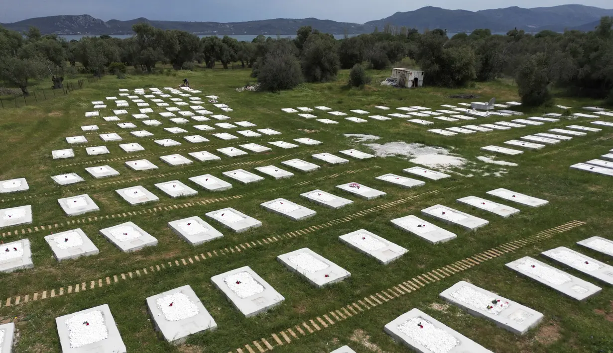 Sebelum intervensi, kuburan yang ditumbuhi rumput liar ditandai dengan batu sederhana dengan nomor tertulis di atasnya, atau, dalam kasus yang jarang terjadi jika tersedia, dengan nama. (AP Photo/Panagiotis Balaskas)