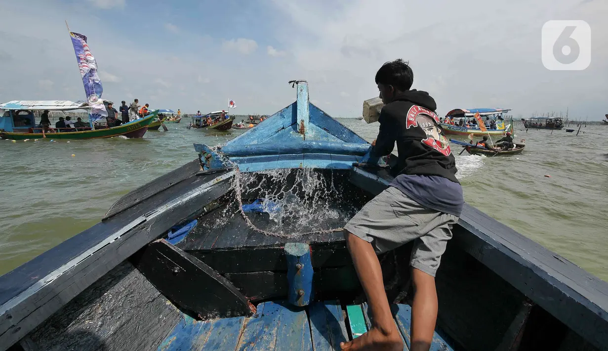 Sejumlah nelayan bersiap untuk melarung replika kapal berisi sesaji di Pantai Tarumajaya, Kabupaten Bekasi, Jawa Barat, Jumat (28/1/2022). Ritual sekaligus bentuk permohonan doa agar diberikan keselamatan dalam melaut. (Liputan6.com/Herman Zakharia)