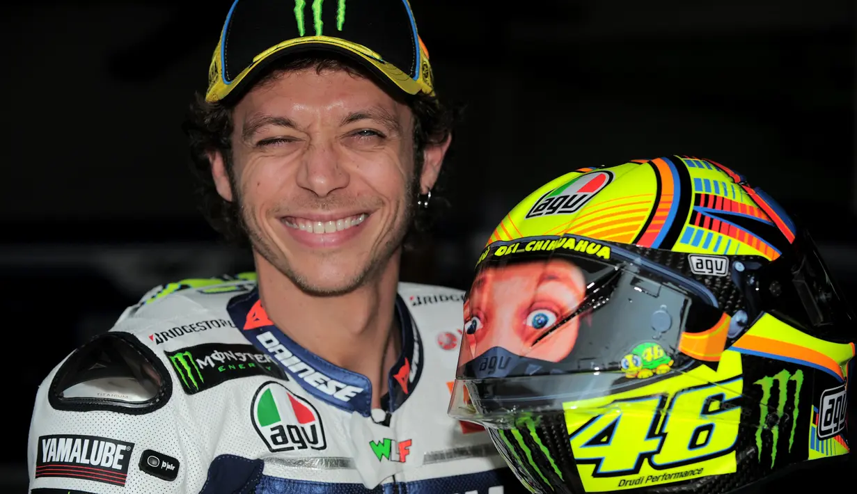 Pebalap MotoGP asal Italia, Valentino Rossi memegang helm saat pra musim di Sirkuit Sepang, Malaysia, Selasa (4/2/2014). (AFP/Mohd Rasfan)