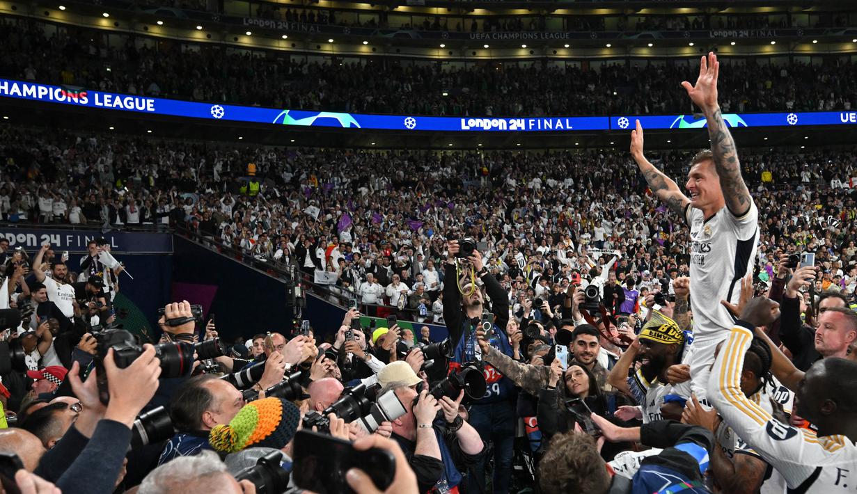 Gelandang Real Madrid, Toni Kroos (kanan) saat merayakan kemenangan bersama para suporter usai memenangi Liga Champions 2023/2024 melawan Borussia Dortmund di stadion Wembley, London, pada 1 Juni 2024. (Glyn KIRK/AFP)