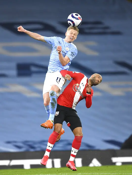 Pemain Manchester City Oleksandr Zinchenko (kiri) memperebutkan bola udara dengan pemain Southampton Nathan Redmond pada pertandingan Liga Inggris di Etihad Stadium, Manchester, Inggris, Rabu (10/3/2021). Manchester City menang 5-2. (Gareth Copley/Pool via AP)