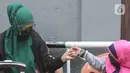 Warga saat akan dibawa ke wisma atlet di Jalan As-Syafiiyah, Cipayung, Jakarta, Jumat (21/5/2021). Klaster Halal Bihalal di Cipayung bertambah 32 orang dari 51 orang menjadi 83 orang terpapar COVID-19 perhari ini. (Liputan6.com/Herman Zakharia)