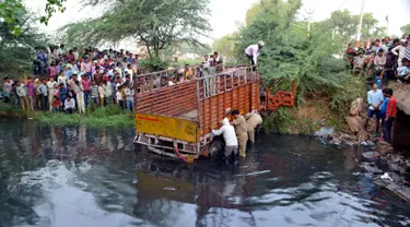 Sebuah truk yang membawa sejumlah orang usai kembali dari upacara pernikahan masuk ke sungai di Etah, India, Jumat (5/5).  Sekitar 14 orang dikabarkan meninggal dalam peristiwa tersebut. (AFP/STR)