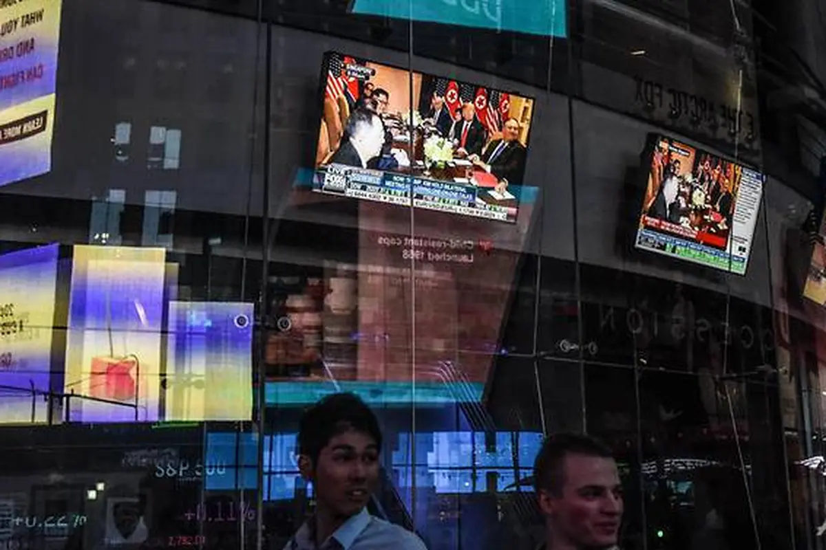 Layar televisi di New York Times Square menayangkan pertemuan bersejarah Donald Trump di Singapura. (AFP)