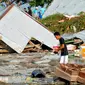 Seorang pria memeriksa kerusakan akibat gempa dan tsunami di Palu, Sulawesi Tengah , Sabtu (29/9). Gelombang tsunami setinggi 1,5 meter yang menerjang Palu terjadi setelah gempa bumi mengguncang Palu dan Donggala. (AP Photo/Rifki)