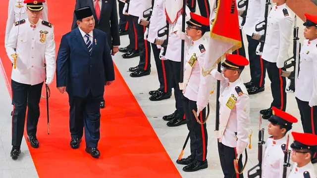 Presiden Prabowo Subianto berjalan berdampingan melewati karpet merah menuju Saluting Dais, tempat utama upacara kenegaraan berlangsung.