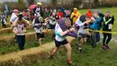 Para peserta melewati rintangan saat Lomba Lari Gendong Istri di The Nower, Dorking, Inggris, Minggu (3/3). Pemenang dari lomba ini akan berlaga di Finlandia untuk menjalani kejuaraan tingkat dunia. (Gareth Fuller/PA via AP)