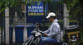 Seorang pengantar barang melewati papan reklame yang menunjukkan dukungan untuk Ukraina yang dipajang di sela-sela pagar Kedutaan Besar Slovakia di Beijing, Kamis (17/5/2023). Kedutaan-kedutaan besar di Beijing telah diminta oleh pemerintah China untuk menghindari propaganda setelah beberapa pengibaran bendera Ukraina atau memasang plakat yang menyatakan dukungan untuk Ukraina. (AP Photo/Andy Wong)