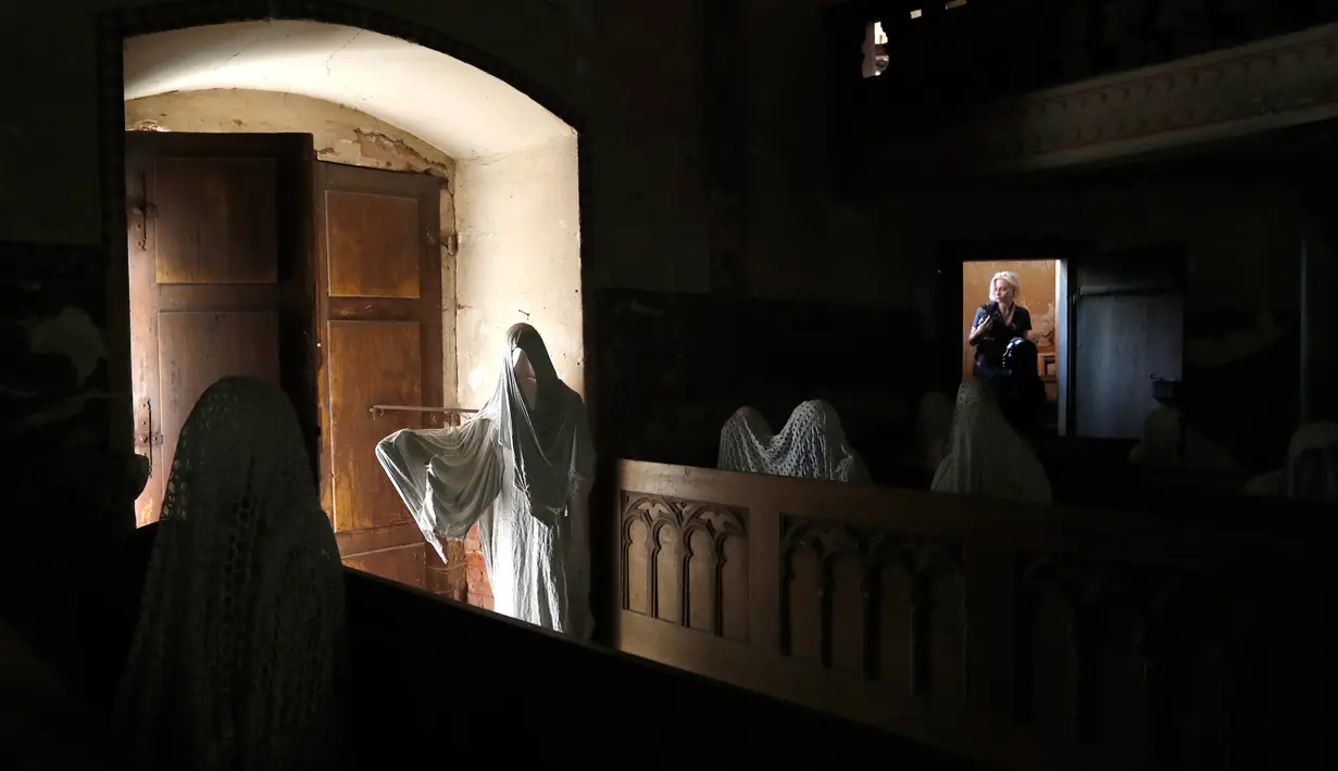 Turis Prancis mengunjungi Gereja St George yang menampilkan patung-patung serupa hantu di Lukova, Republik Ceko, 30 Agustus 2018. Walau instalasinya begitu menyeramkan, tidak sedikit turis yang singgah di gereja itu karena penasaran. (AP/Petr David Josek