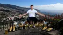 Bintang Real Madrid, Cristiano Ronaldo berpose di depan seluruh trofinya dengan memunggungi panorama pegunungan di Madeira, Portugal, 1 Januari 2018. Di depan Ronaldo, tersusun semua trofi pribadi yang telah berhasil diraihnya. (Handout/CR7 Media/AFP)