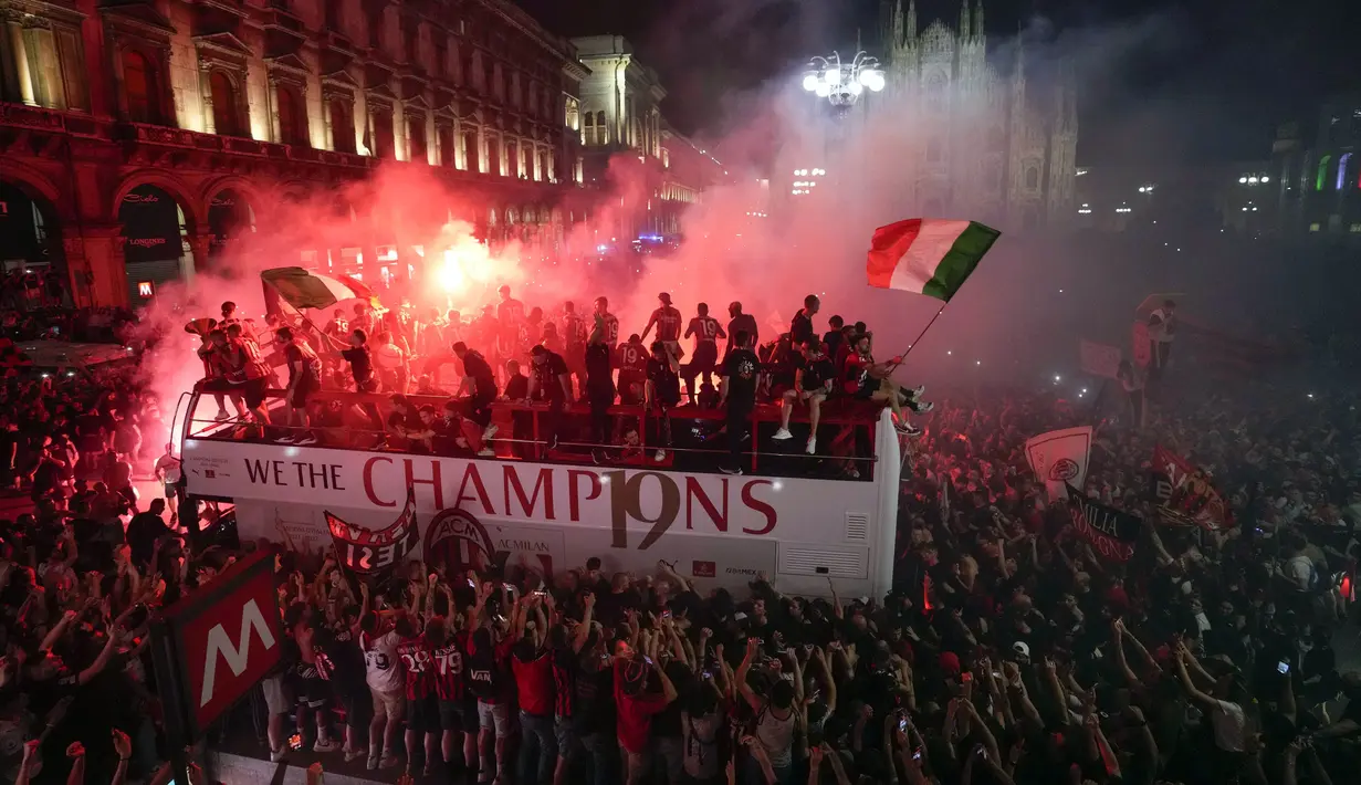 Ribuan penggemar bersorak saat bus yang membawa para pemain tim sepak bola AC Milan melakukan parade kemenangan Liga Italia di depan Katedral Gotik Milan, Milan, Italia, 23 Mei 2022. (AP Photo/Luca Bruno)