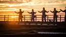 Praktisi Tai Chi melakukan latihan dengan latar belakang matahari terbenam di atas Jembatan Sydney Harbour, Australia, Selasa (2/5). Acara ini diselenggarakan oleh Akademi Tai Chi dan Qigong Australia. (Handout / BRIDGECLIMB SYDNEY / AFP)