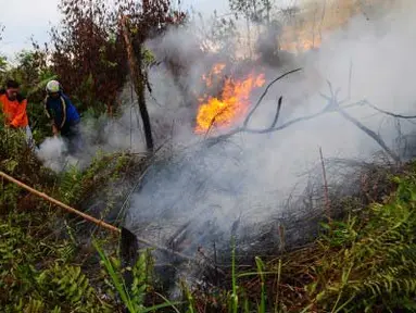 Dua anggota Taruna Siaga Bencana berupaya memadamkan api yang menjalar di lahan hutan, di kawasan Jalan Sepakat II, Pontianak, Kalbar, Senin (2/4). Berdasarkan pantauan Badan Lingkungan Hidup Daerah Kalbar, dalam sepekan ini terdapat 54 titik panas yang terjadi akibat pembakaran lahan di sejumlah kabupaten di wilayah Kalbar. (Antara)
