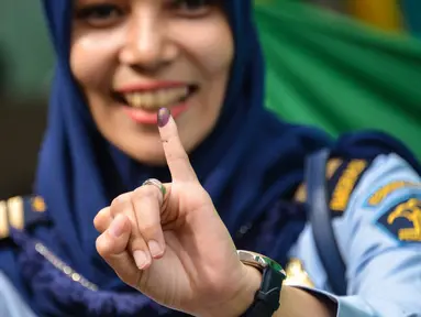 Warga menunjukkan jari kelingking usai mencoblos pada pemungutan suara ulang pemilu 2019 di TPS-6 Desa Lamteumen Timur, Banda Aceh, Aceh, Kamis (25/4). Pemungutan suara ulang karena adanya penggunaan formulir C6 pemilih yang telah meninggal pada pemilu 17 April lalu. (CHAIDEER MAHYUDDIN/AFP)