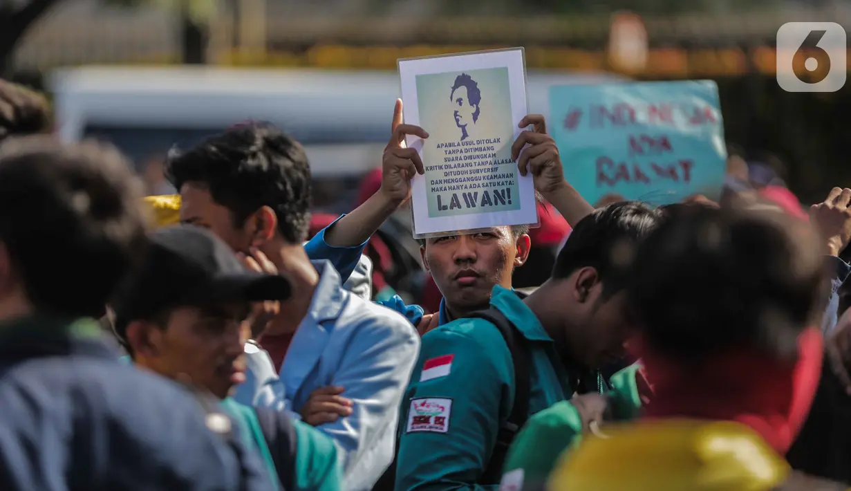 Massa mahasiswa dari BEM Seluruh Indonesia (SI) membawa poster dalam unjuk rasa di kawasan Patung Kuda, Jakarta, Senin (21/10/2019). Massa yang akan berunjuk rasa di depan Istana Merdeka tertahan di Patung Kuda karena terhalang kawat berduri yang dibentangkan. (Liputan6.com/Faizal Fanani)