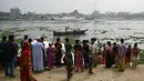 Orang-orang menyaksikan petugas pemadam kebakaran mencari korban kecelakaan feri di Sungai Shitalakshya di Narayanganj, Bangladesh (21/3/2022). Feri ML Afsar Uddin tenggelam di sungai setelah ditabrak kapal kargo. (AFP/Munir uz Zaman)