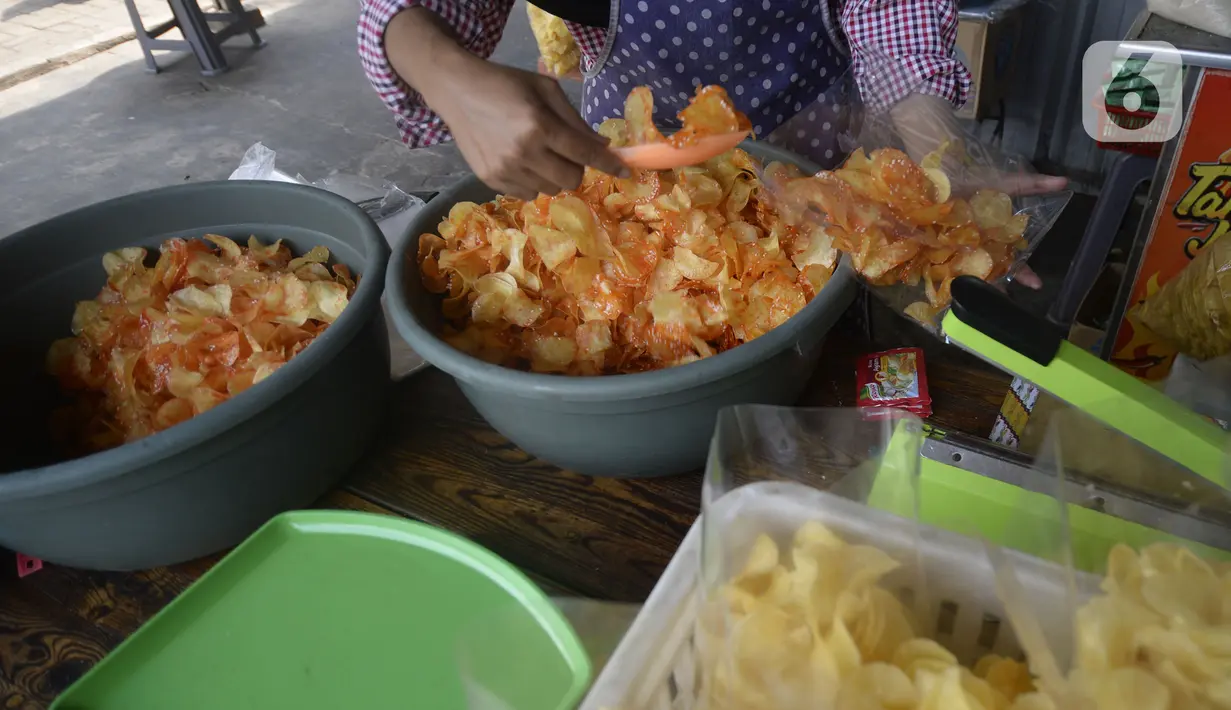 Pekerja mengemas keripik singkong rumahan yang telah matang di Kampung Kopi, Gunung Sindur, Bogor, Jawa Barat, Selasa (8/9/2020). Camilan yang dijual dengan harga Rp 8 ribu hingga Rp 50 ribu tergantung rasa tersebut banyak diminati warga di masa pandemi. (merdeka.com/Dwi Narwoko)