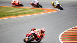 Pembalap Repsol Honda, Marc Marquez (depan) bersaing menjadi yang terdepan pada Grand Prix MotoGP di Sirkuit Sachsenring ,Jerman, Minggu (12/7/2015). Marc Marquez sudah kelima kalinya menaklukan sirkuit ini. (REUTERS / Hannibal Hanschke)
