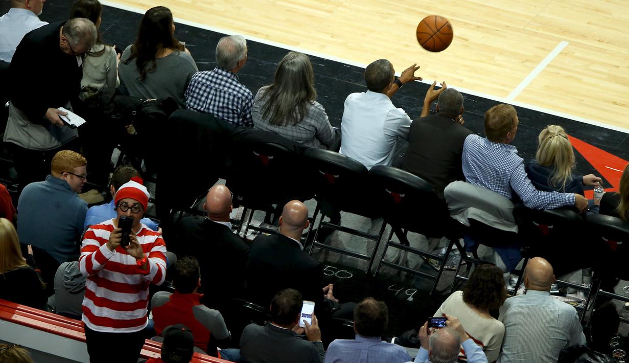 President Amerika Serikat Barack Obama melempar bola pada pembukaan NBA antara  Cleveland Cavaliers melawan Chicago Bulls di Chicago, Selasa(27/10/2015). (REUTERS / Jonathan Ernst)