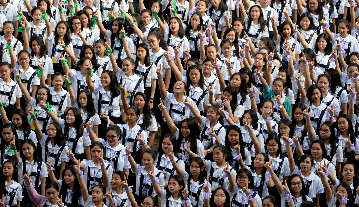 Ribuan siswa St. Scholastica College mengacungkan jari telunjuk "nomor satu" saat menari massal dalam aksi One Billion Rising di Filipina, Senin (15/2). Gerakan ini bentuk kampanye untuk menghentikan kekerasan terhadap perempuan. (AFP PHOTO/Noel CELIS)
