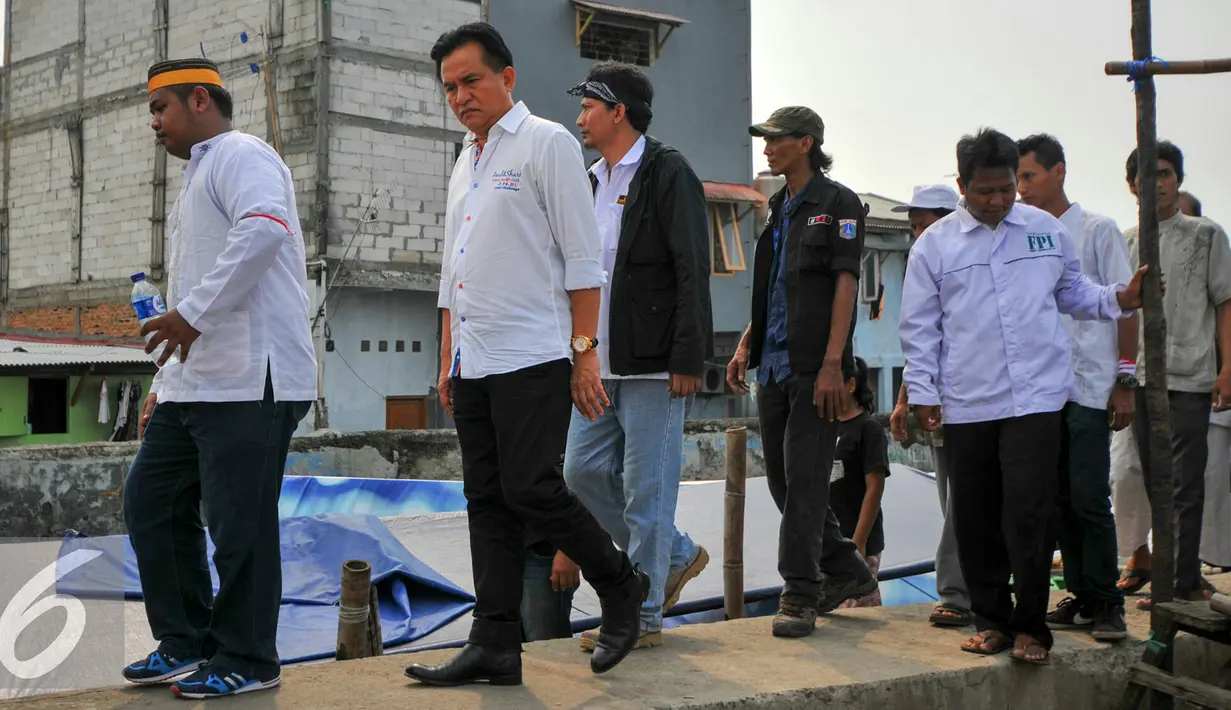 Bacagub DKI Jakarta, Yusril Ihza Mahendra berjalan untuk menemui warga penggusuran Pasar Ikan, Penjaringan, Jakarta, Rabu (20/4). Sejumlah warga pasar ikan bertahan di lokasi penggusuran dan memilih tinggal di perahu. (Liputan6.com/Yoppy Renato)